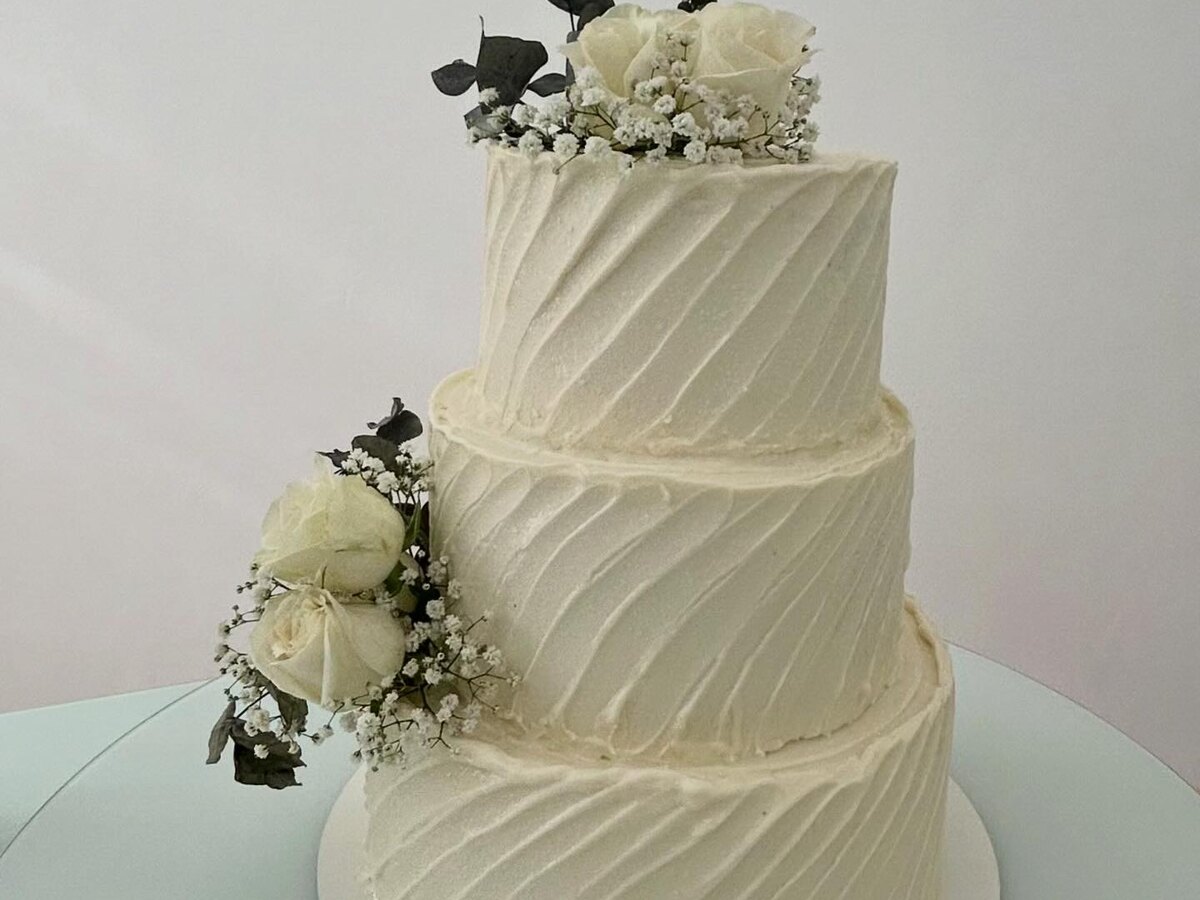 Bolo de casamento de três andares com textura em babado e rosas brancas naturais